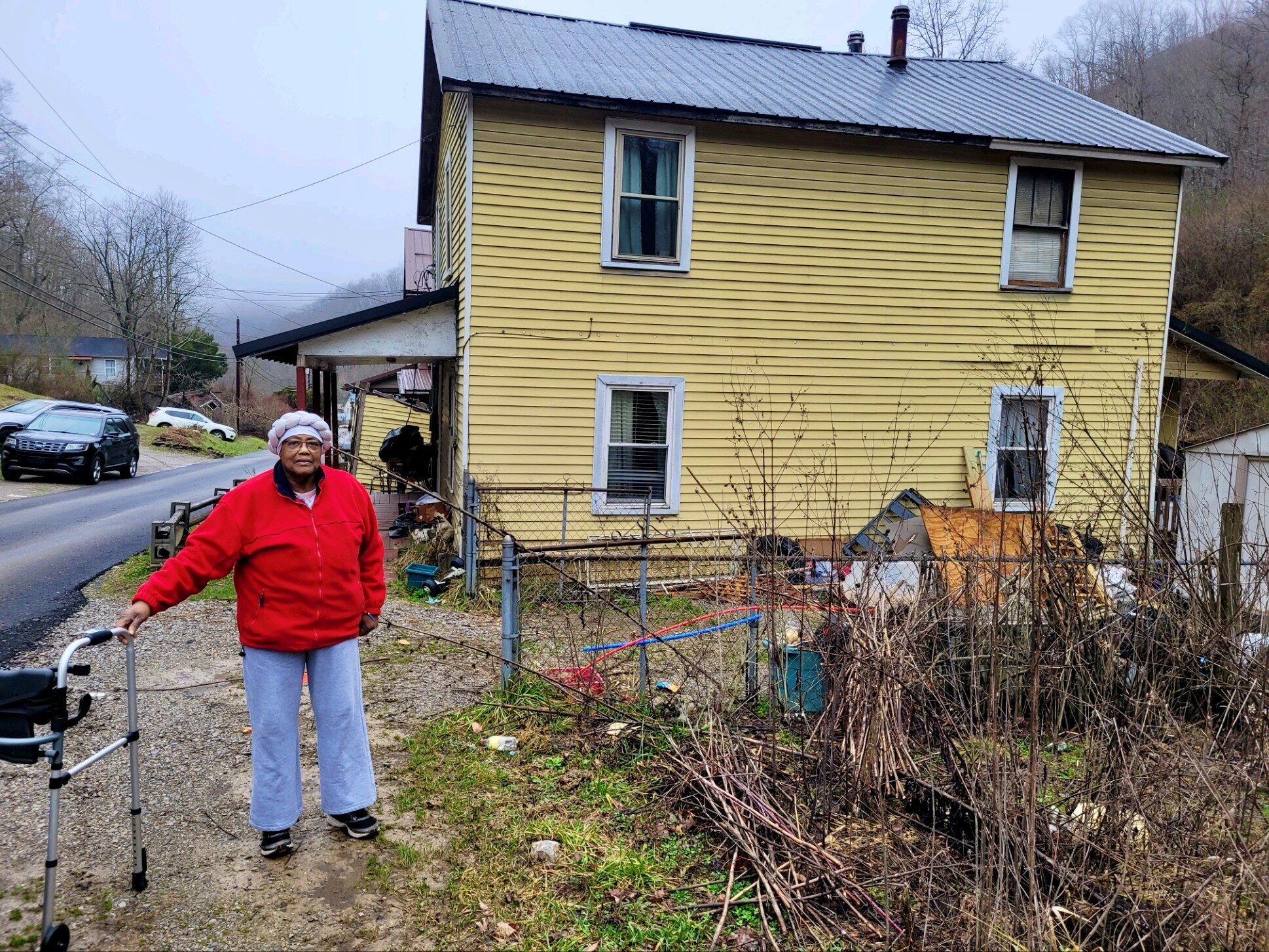 Lois Thompson stands outside her old house